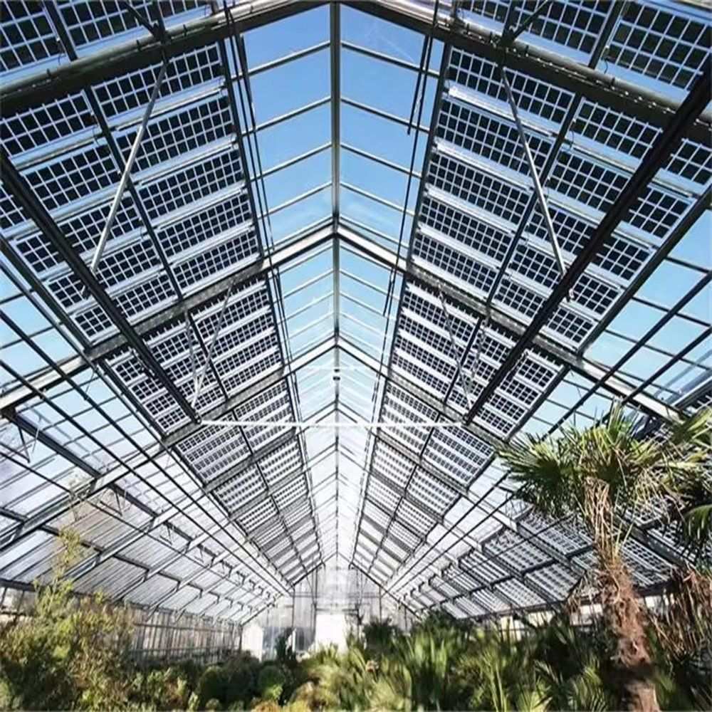Photovoltaic panel rows mounted on the roof of a glass greenhouse