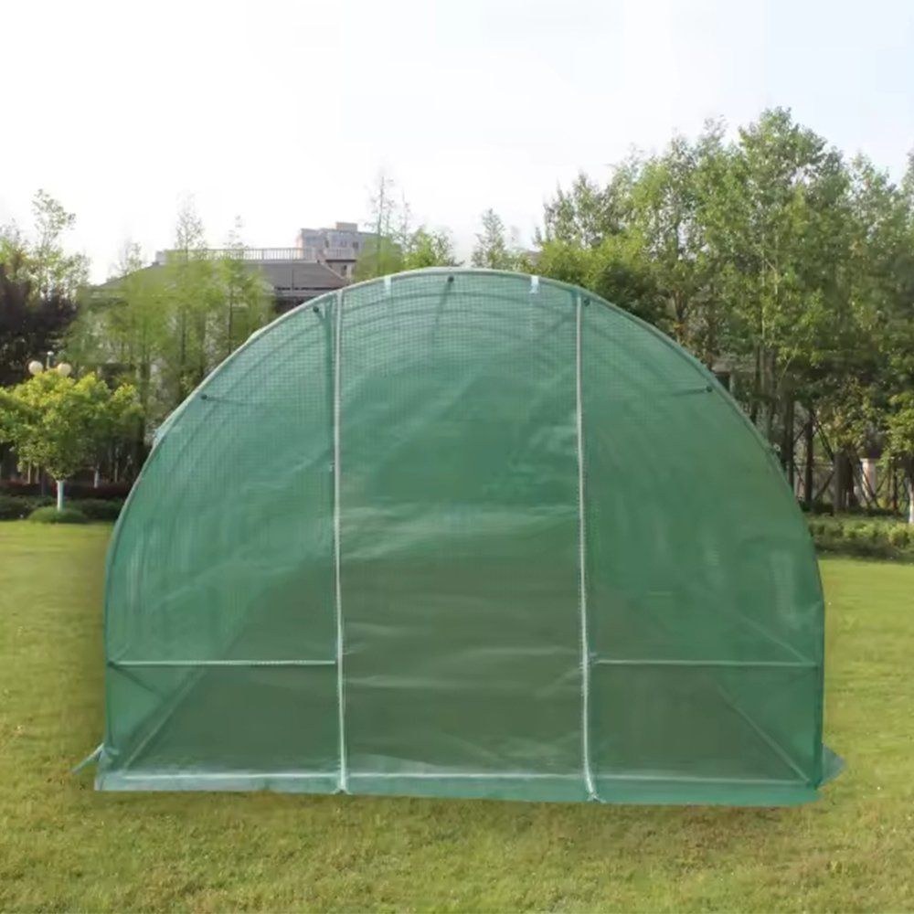 Green mesh polytunnel greenhouse standing in a garden setting