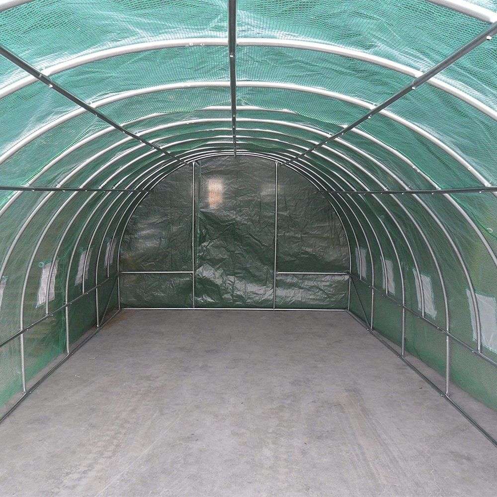Interior of a green mesh tunnel greenhouse with a zipped end door