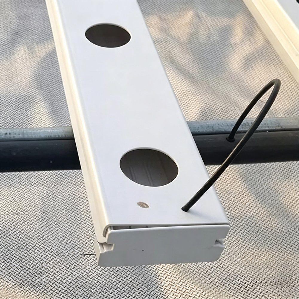 Close view of a white food grade PVC growing channel and a black feed line