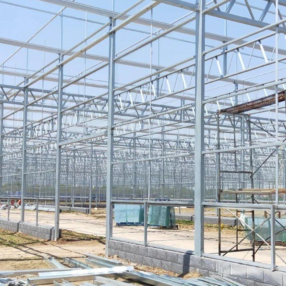 steel greenhouse frame under erection on a construction site