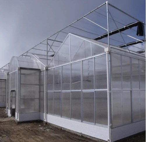 Multi-span commercial polycarbonate greenhouse exterior with gable ends