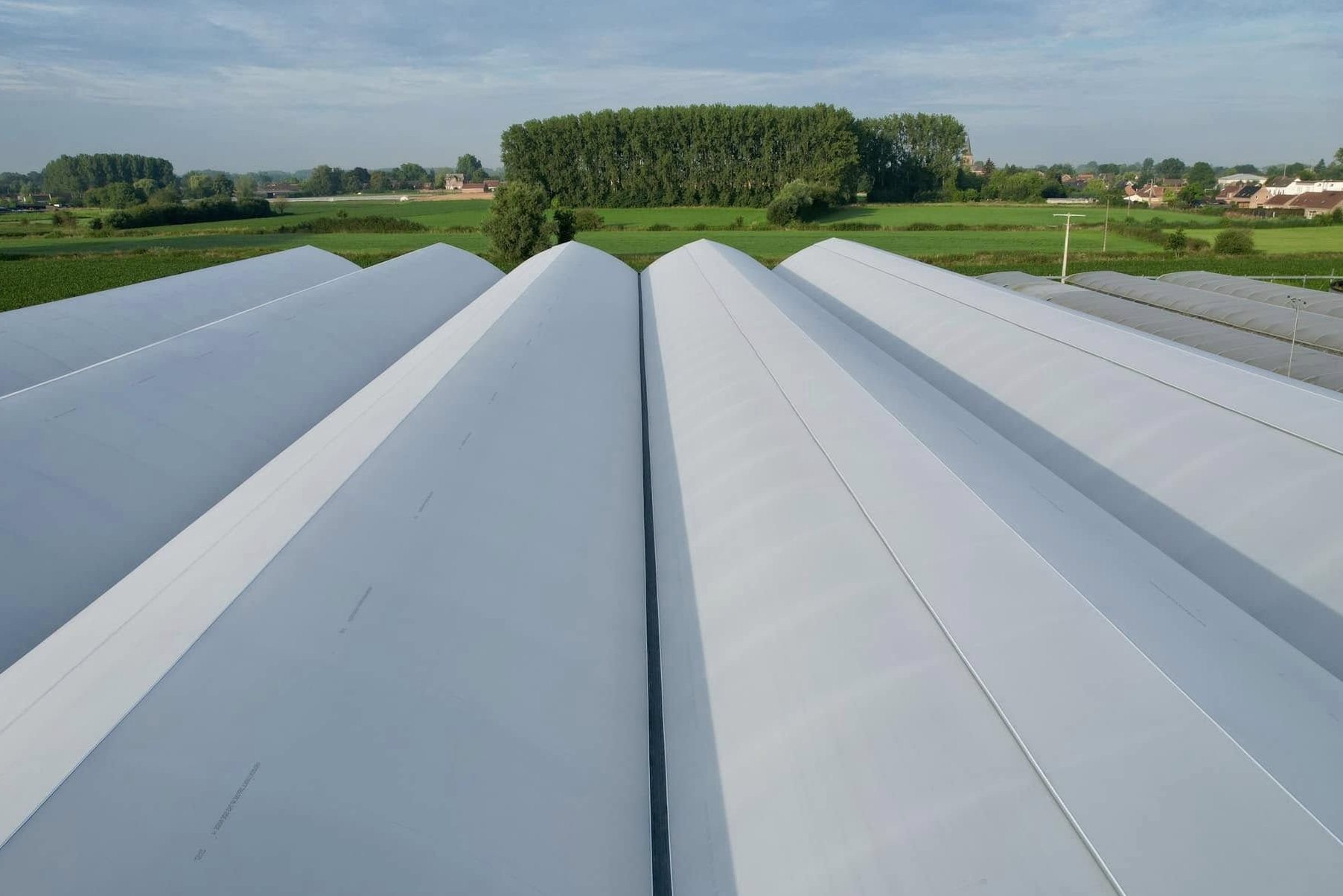 Long rows of film greenhouses seen along the ridge line