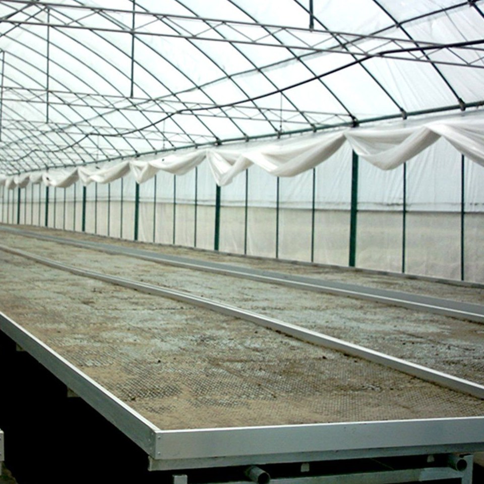 Growing bench with sensor and control boxes inside a cloud connected glass greenhouse