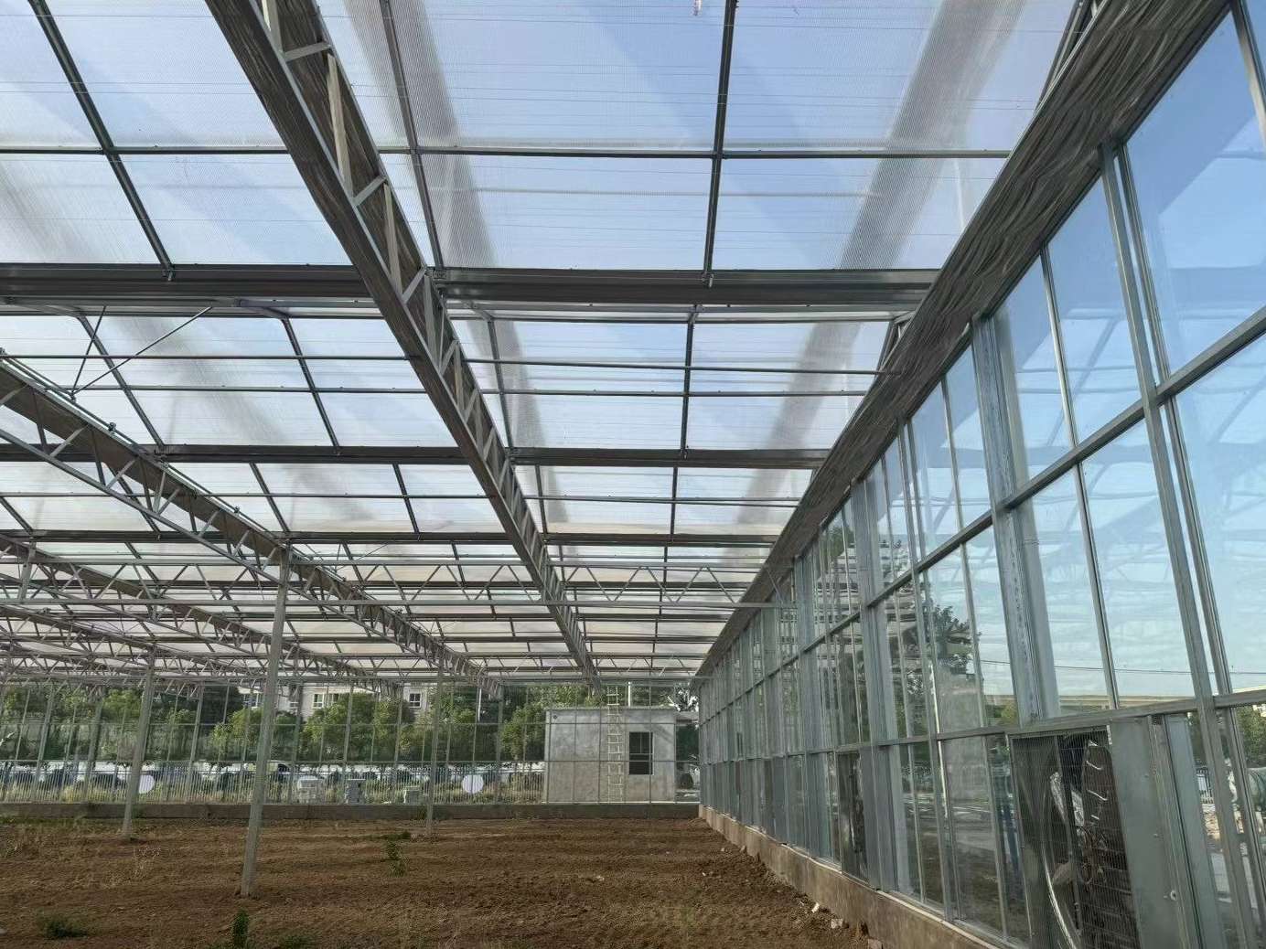 Interior of a multi span glass greenhouse looking along the bays and gutter lines