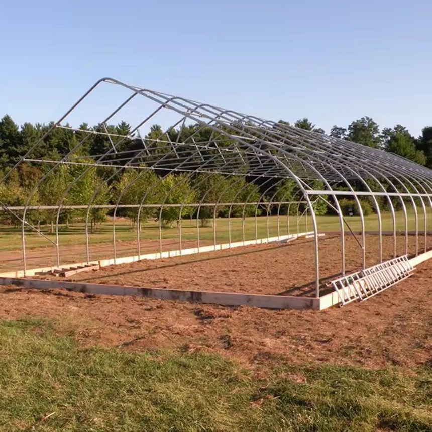 Bare galvanized hoops and purlins of a single span greenhouse