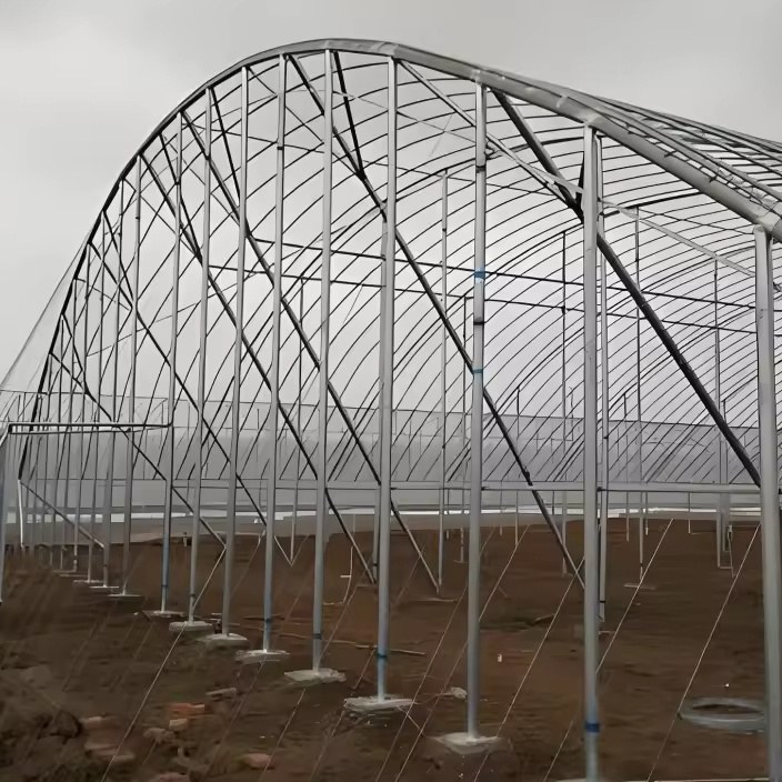 Bare galvanized gothic arch frames standing on pad foundations