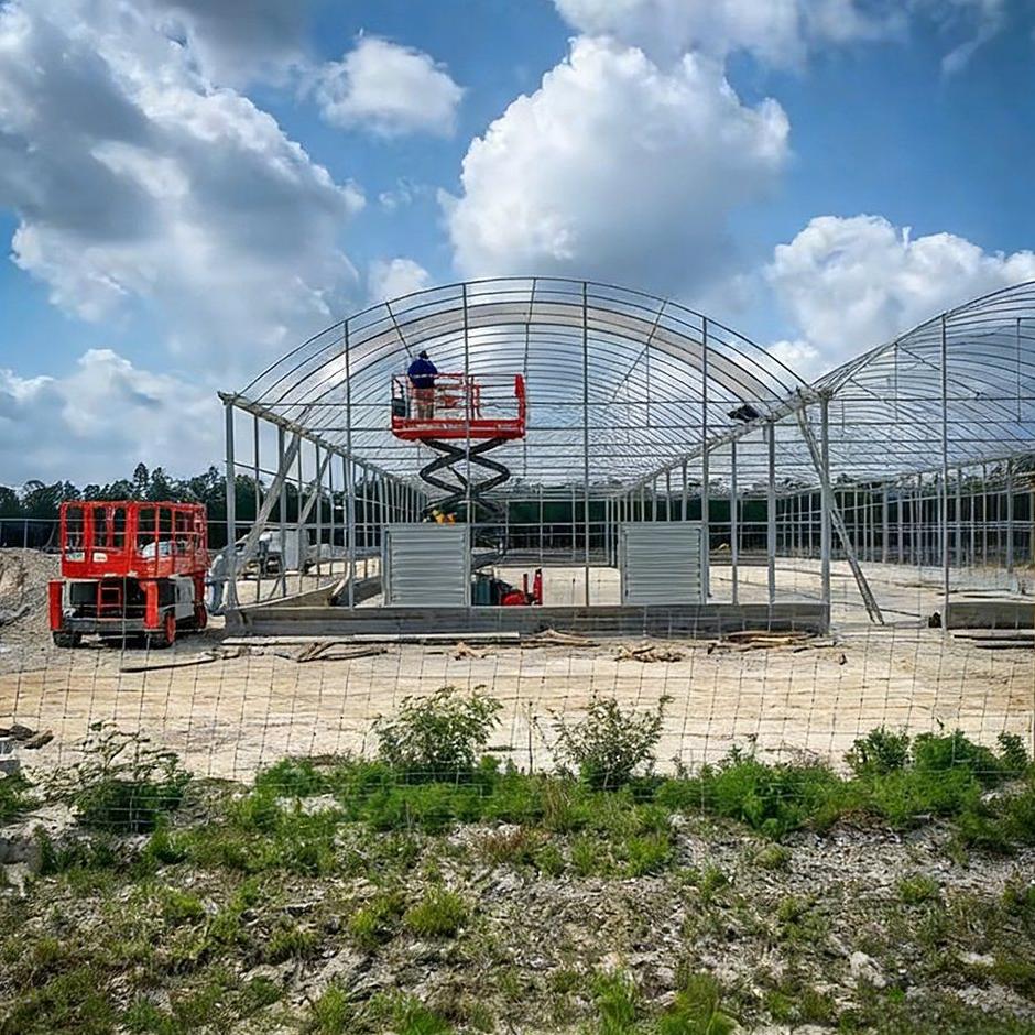 galvanized steel arch frame under erection on a greenhouse site