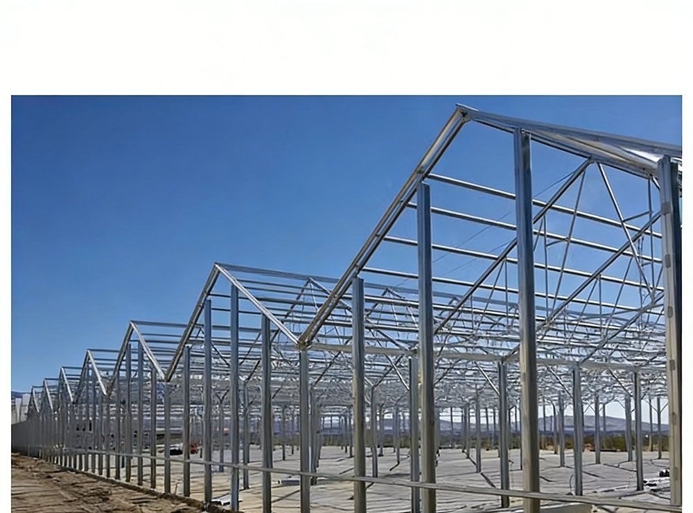 Bare galvanized steel frames of a multi span greenhouse before glazing