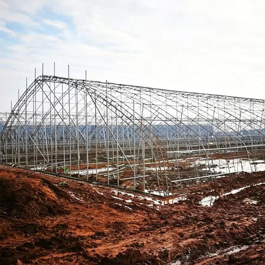 Bare galvanized steel arches of a tunnel greenhouse before covering