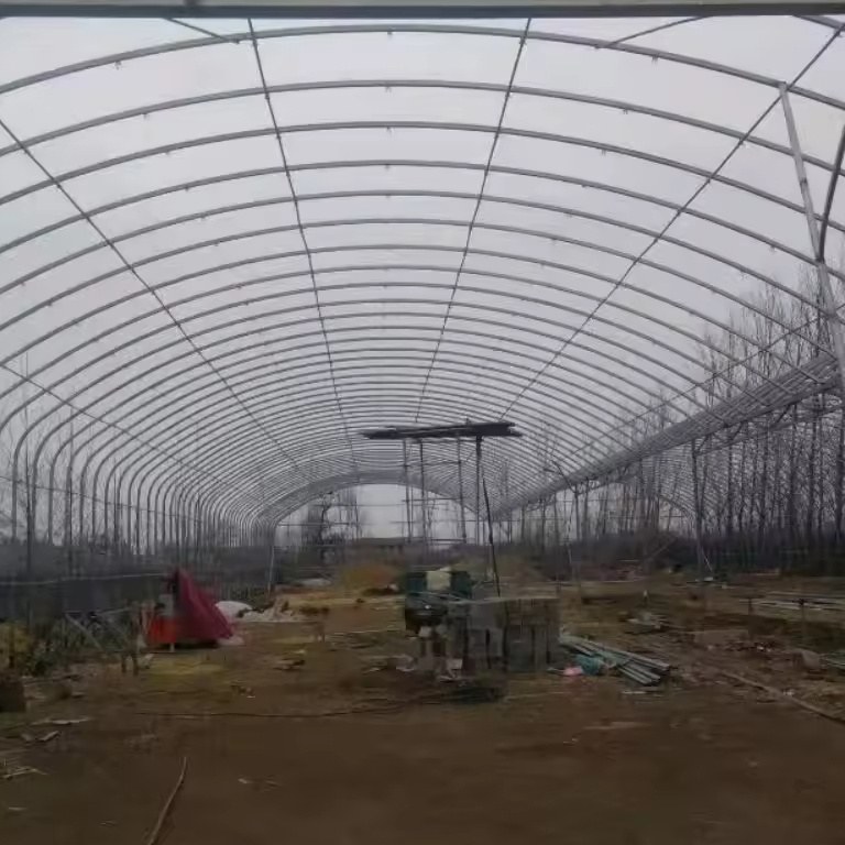 Long interior view of a single span high tunnel greenhouse during construction