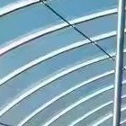 Arched roof frame and film cover of a tunnel greenhouse against a blue sky