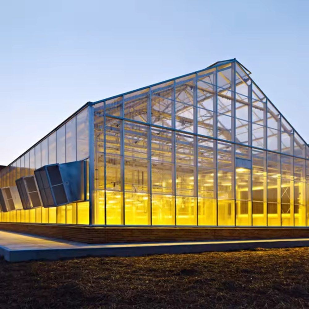 Gable greenhouse lit from inside at dusk