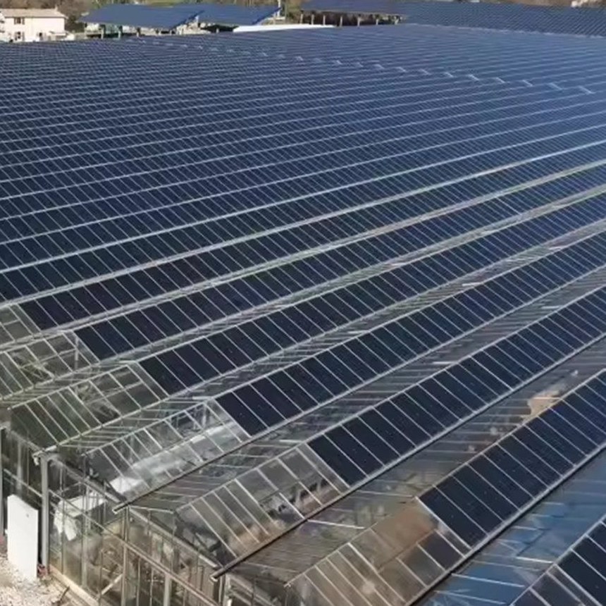 Large glass greenhouse fully covered with a rooftop solar array