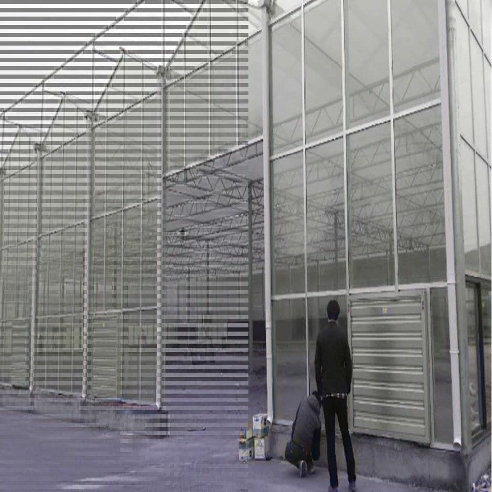 Glass house wall with a person working beside a louvre panel