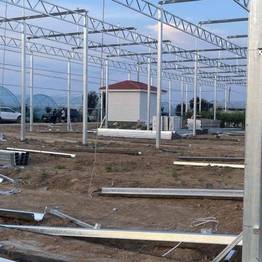 Glass greenhouse frame set out on a prepared site during construction
