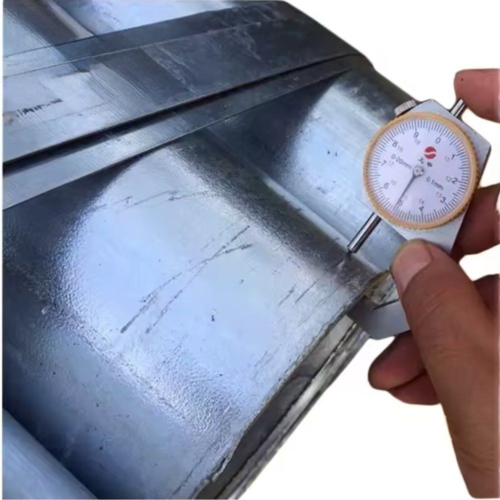 Caliper measuring the wall thickness of a galvanized steel pipe