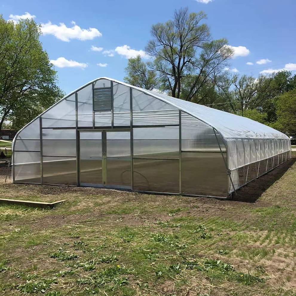 Single span film greenhouse standing on a lawn