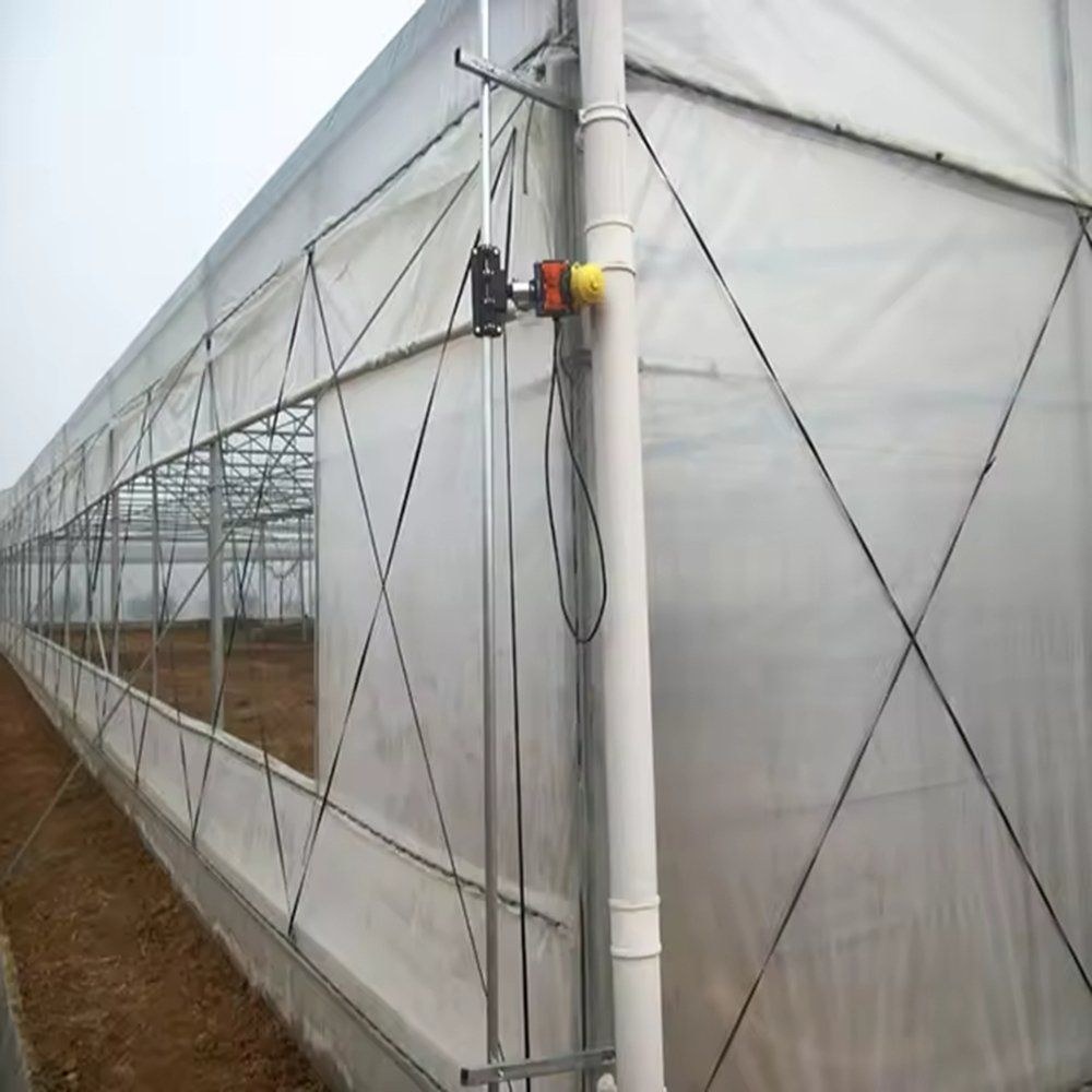Side wall of the greenhouse with the steel column, gutter and a pipe running down