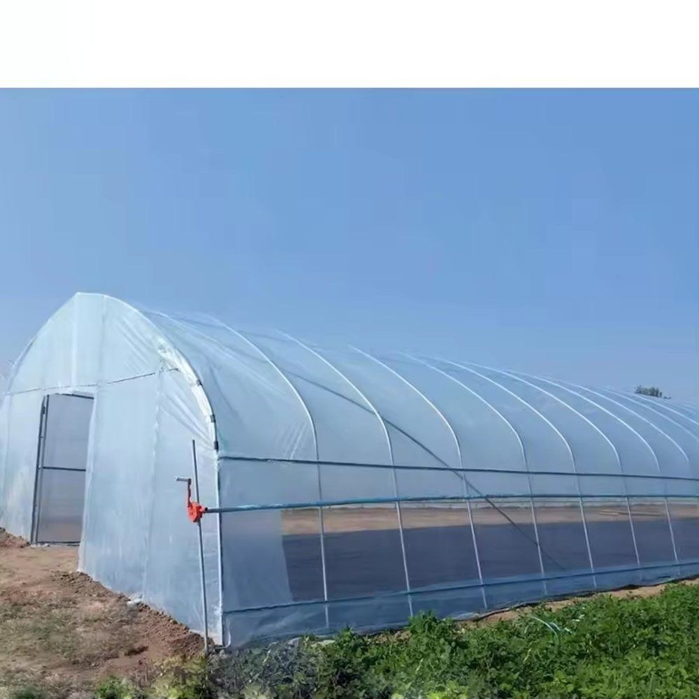 Arched film greenhouse standing on open grass