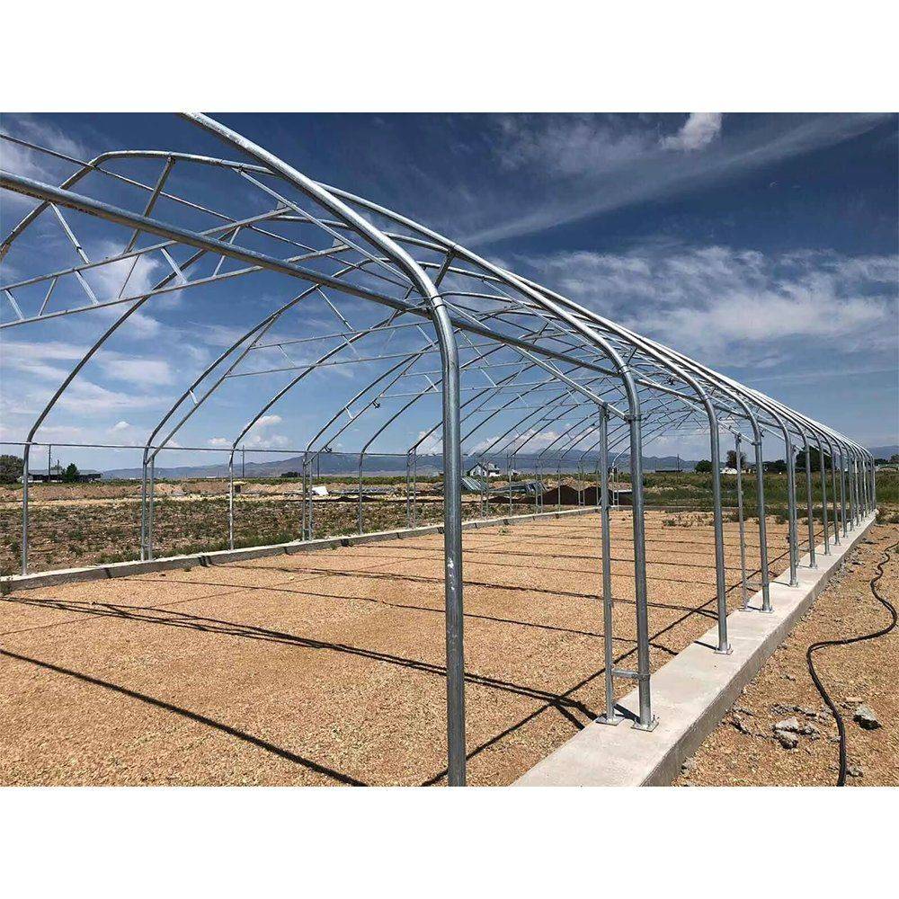 Tunnel greenhouse frame under construction on a prepared site