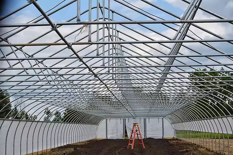 Arch greenhouse frame bays standing on a prepared site