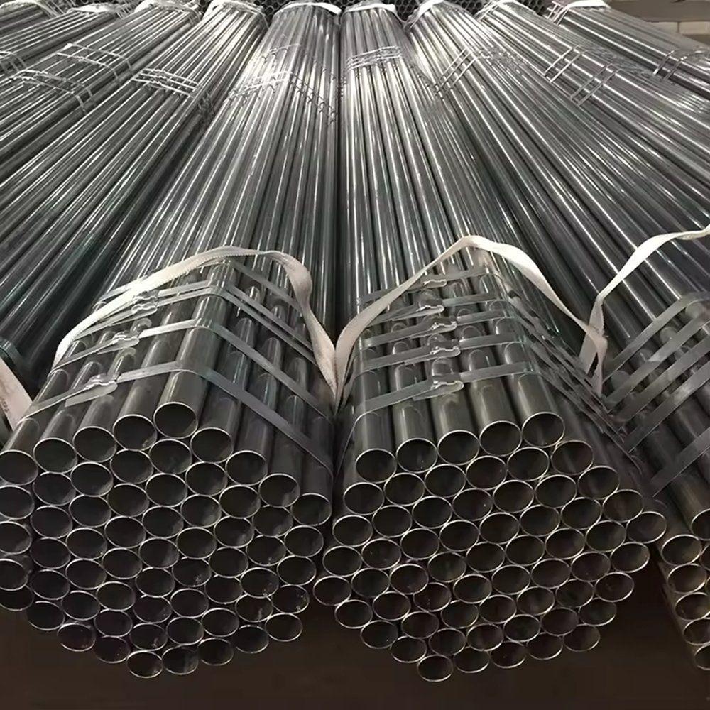 Long galvanized steel pipes stacked in a warehouse