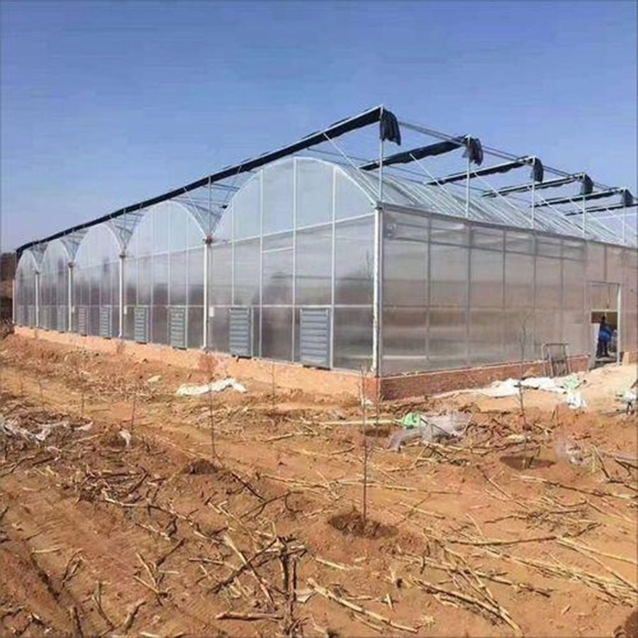 Arched greenhouse frame and cover on a cleared construction site