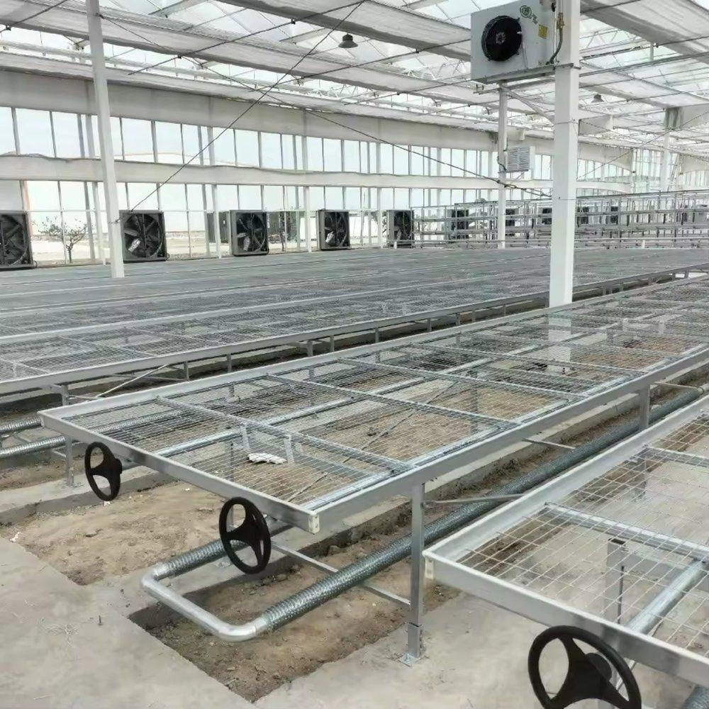 Empty galvanized rolling bench with a wire mesh top and handwheel