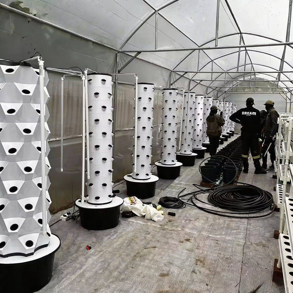 Row of tall white plant towers standing in a greenhouse bay