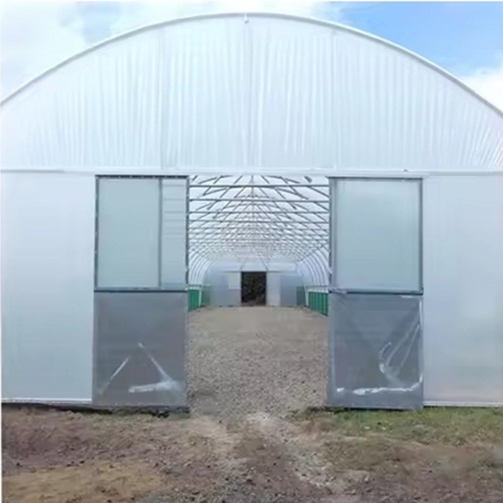 End wall of a gothic arch greenhouse with double doors and a film cover