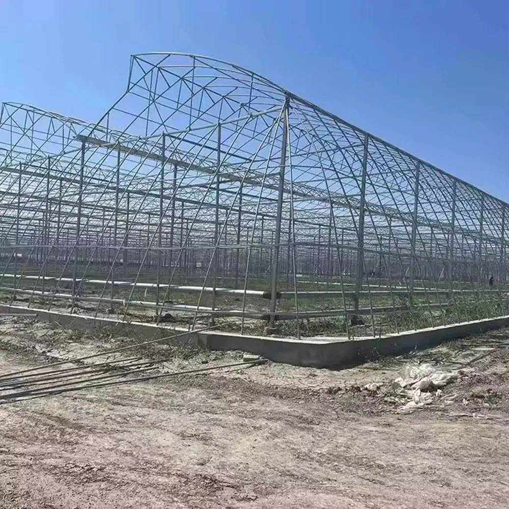 Galvanized frame of a film greenhouse being erected on site