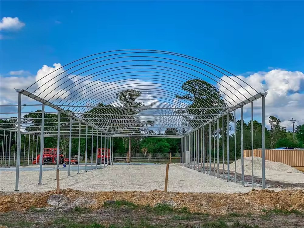 Greenhouse frames and materials laid out on a construction site